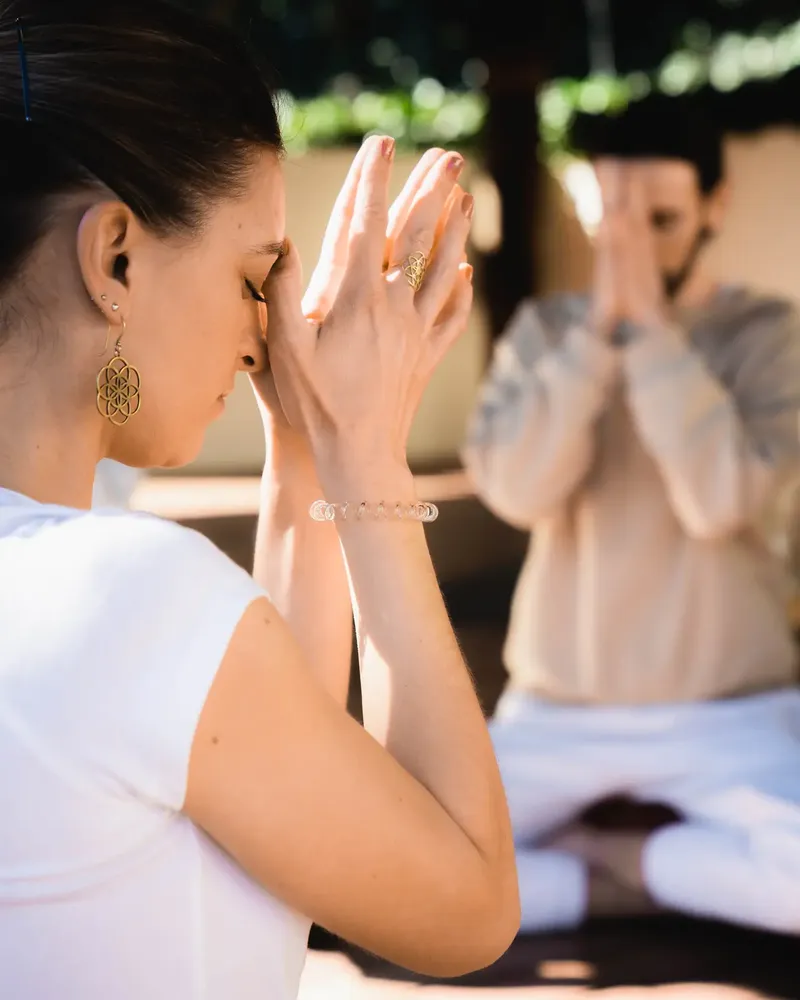 Guests in a guided meditation with hands in prayer position at Shanti-Som Marbella